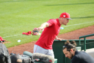 Mike Trout entering spring training dugout with arms spread.